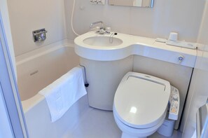 A modern bathroom with a bathtub, a toilet, and a sink. - Yawatajuku Dai Ichi Hotel (Ichihara)