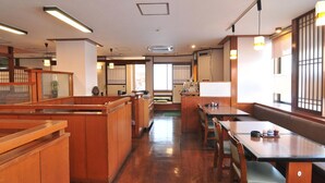 L’intérieur d’un restaurant japonais traditionnel, avec des meubles en bois, des tatamis et des portes coulissantes.