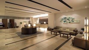 A modern hotel lobby with a reception desk, seating area, and artwork on the walls. - Richmond Hotel Kumamoto Shinshigai (Kumamoto)