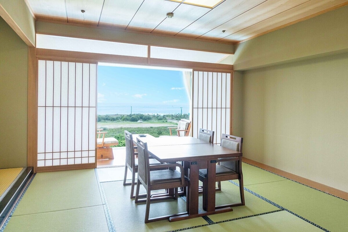 Une pièce de style japonais traditionnel, avec un sol recouvert de tatamis, une table basse et des portes coulissantes.