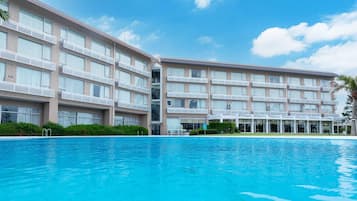 Un hotel con varios pisos, balcones y una piscina.