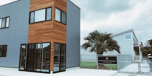 A modern building with a two-story structure, large windows, and a sign indicating a garden terrace. - Hotel Ichinomiya Seaside Otsuka (Ichinomiya)