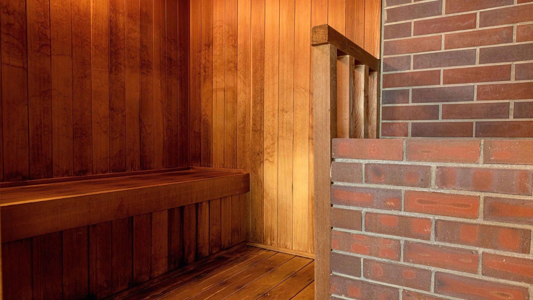A wooden bench and a brick wall, likely part of a building's interior.
