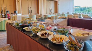 Disposição de buffet com diversos alimentos e utensílios.