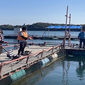 A dock with a netted platform, a chair, and a person wearing an orange vest. - Oyano Yanagiko Onsen Komatsuya Nagisakan (Kamiamakusa)