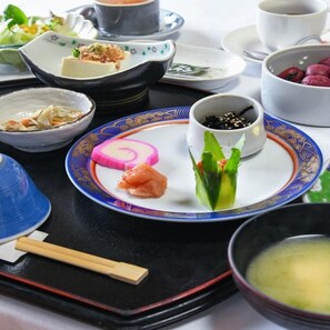 Una variedad de platos en una bandeja, incluyendo sushi, un rollo y un tazón de sopa.