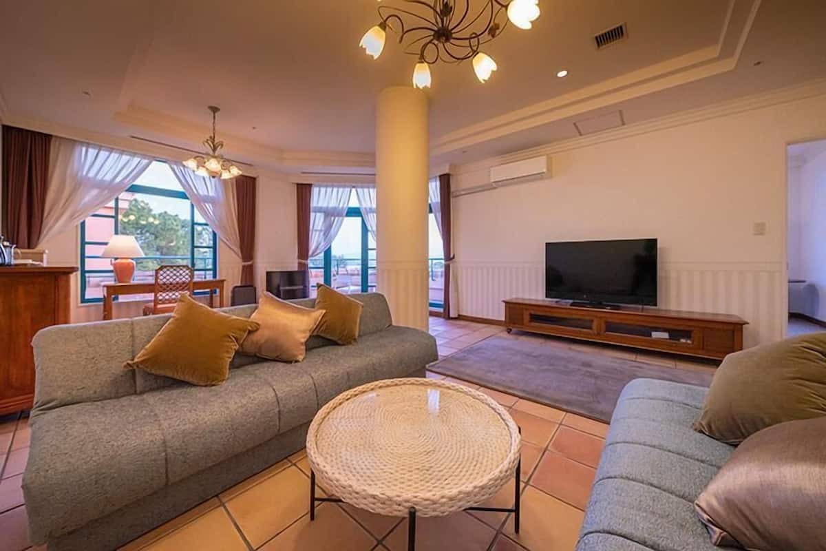 Ein Wohnzimmer mit einer Couch, einem Fernseher und einem runden Kaffeetisch.