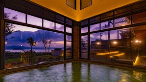 A spacious indoor pool area with large windows offering views of the outdoors. - Ooedo Onsen Monogatari Premium Saikaibashi (Sasebo)