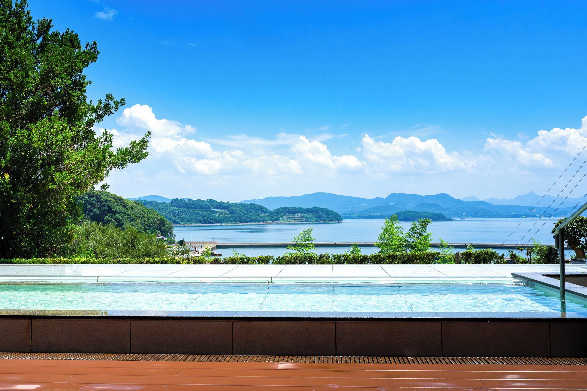 Una piscina con vistas a un lago y montañas.