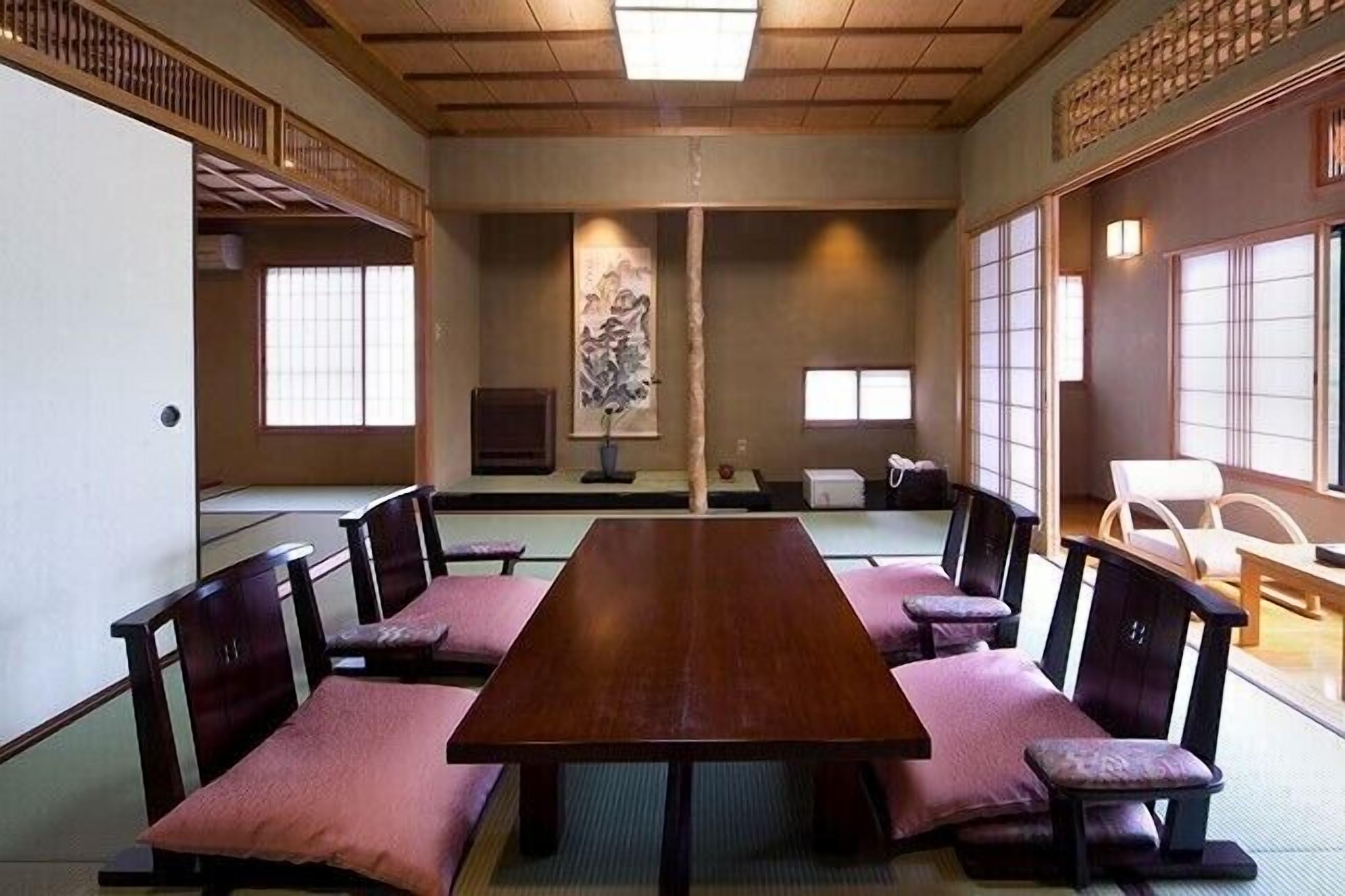 Um quarto japonês tradicional com tatames, uma mesa baixa e biombos shoji.