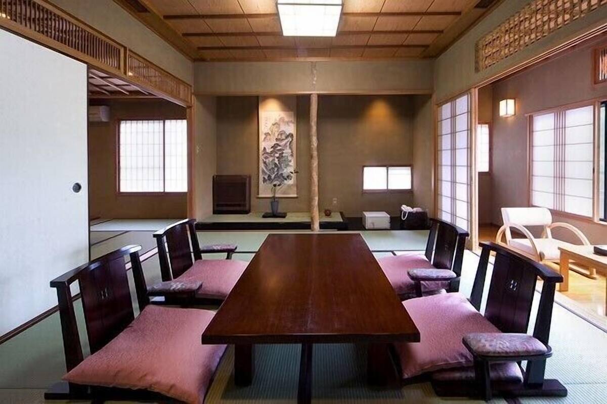 Una habitación japonesa tradicional con suelo de tatami, una mesa baja y paneles shoji.