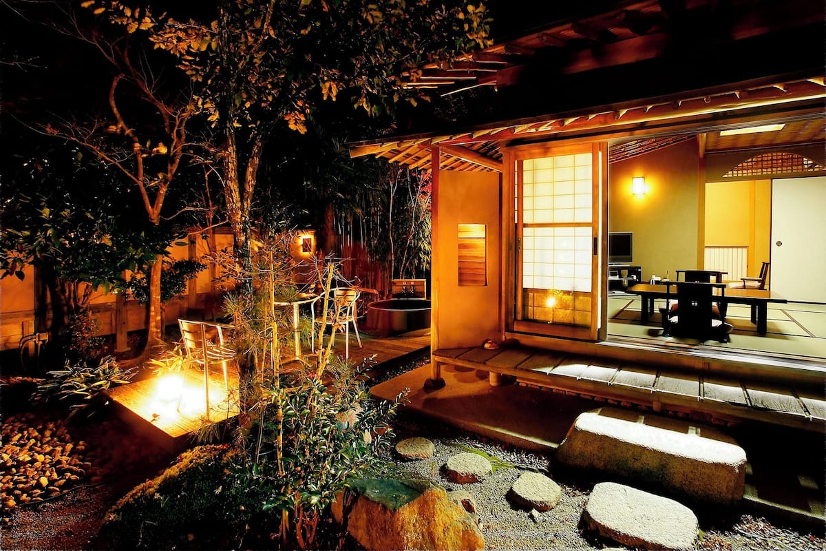 A traditional Japanese-style room with tatami flooring, a low table, and a sliding door.