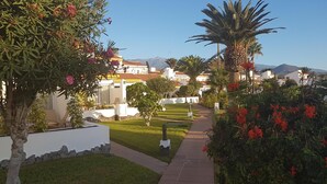Área residencial com casas, um caminho e uma montanha ao fundo.
