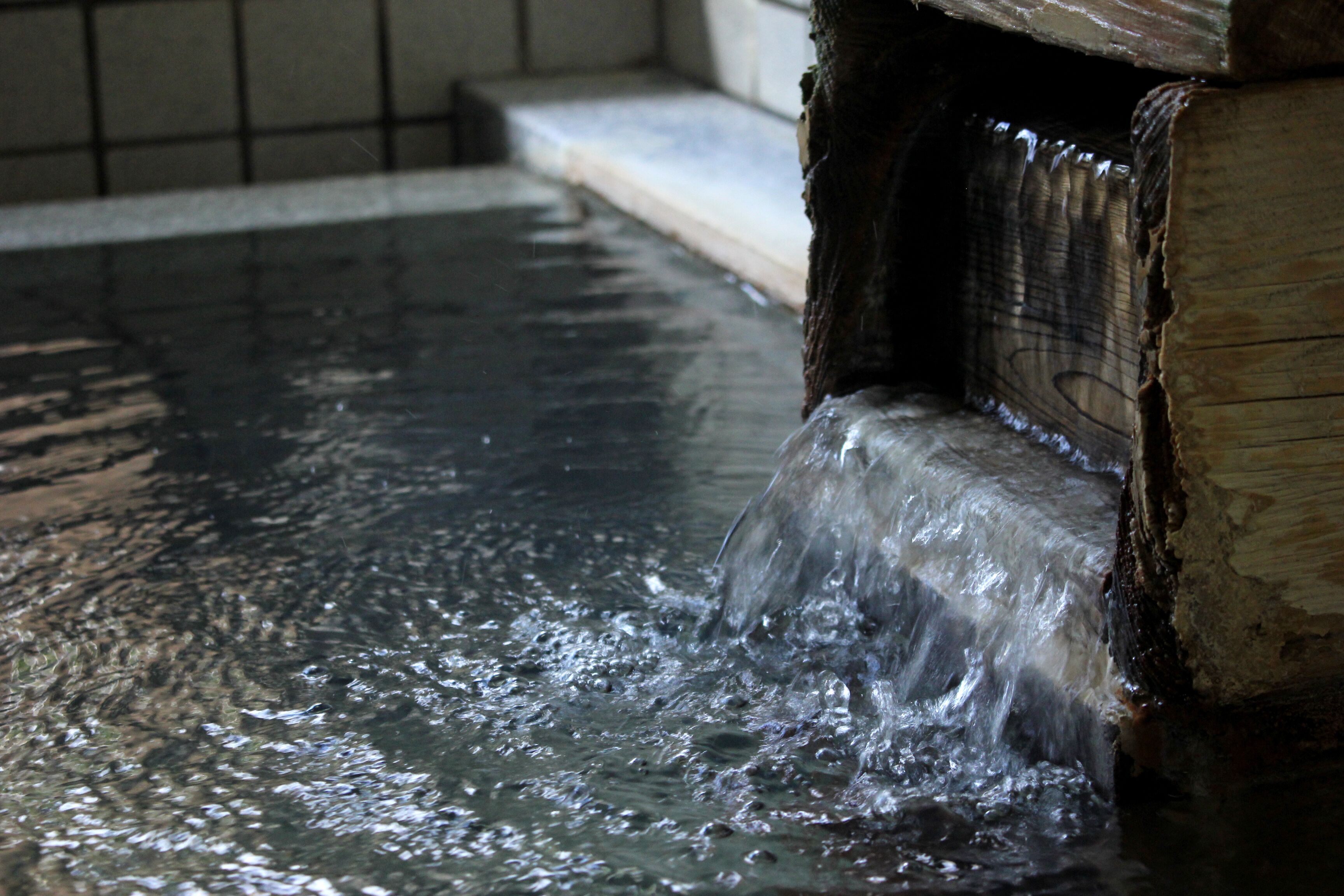 A water feature with a wooden structure and a tiled floor.