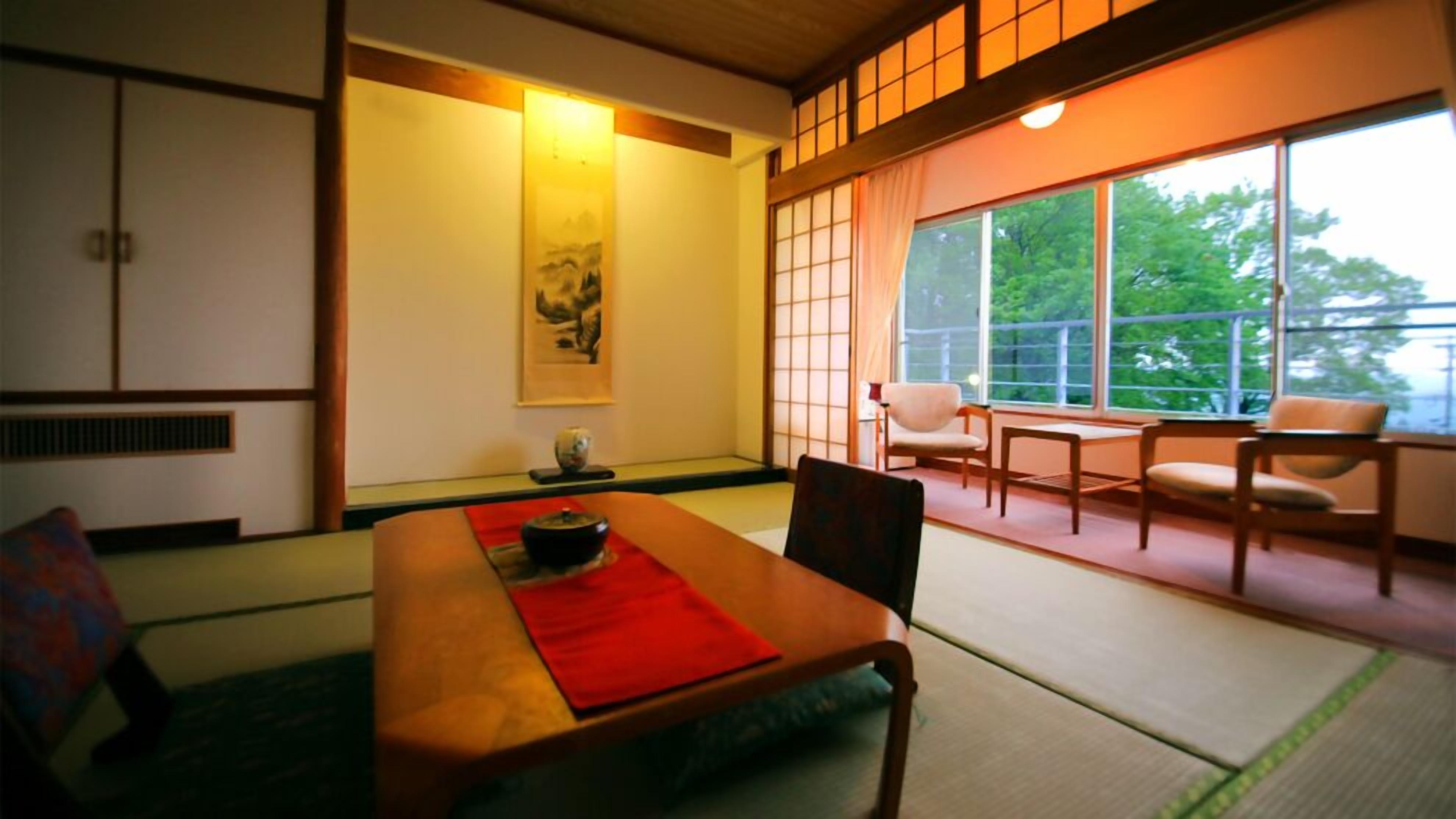 A traditional Japanese room with tatami flooring, a low table, and sliding doors.