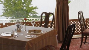 A table set for dining with a view of the sea and a tree in the background. - Hotel Passage Kinkai (Nagasaki)