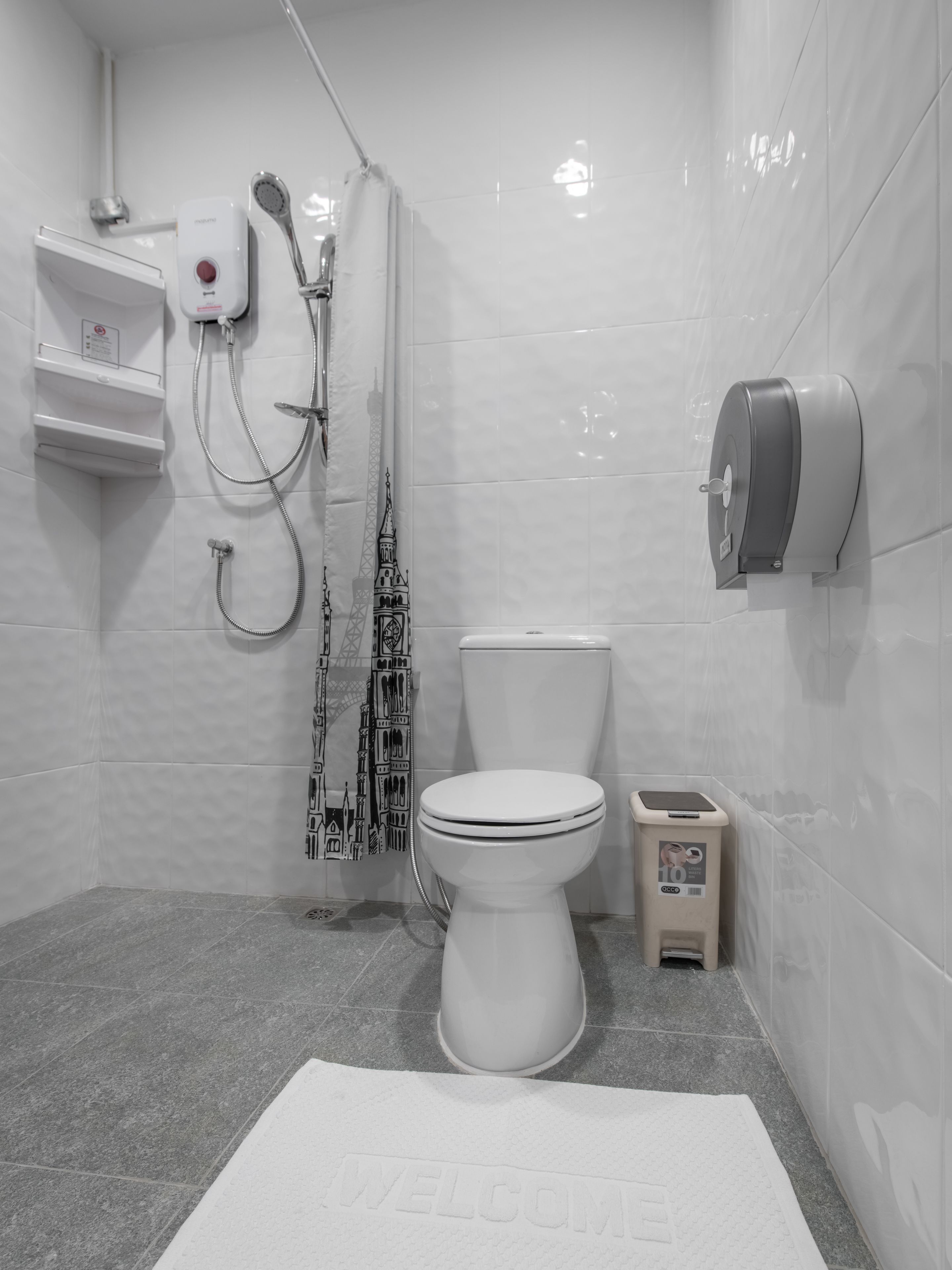 Un baño moderno con inodoro, ducha y secamanos.
