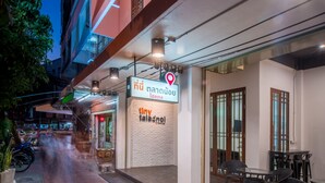 A hotel corridor with a tiled floor, a restaurant named 'tiny talanoa', and a sign indicating a location. - Tiny Taladnoi Hostel (Bangkok)