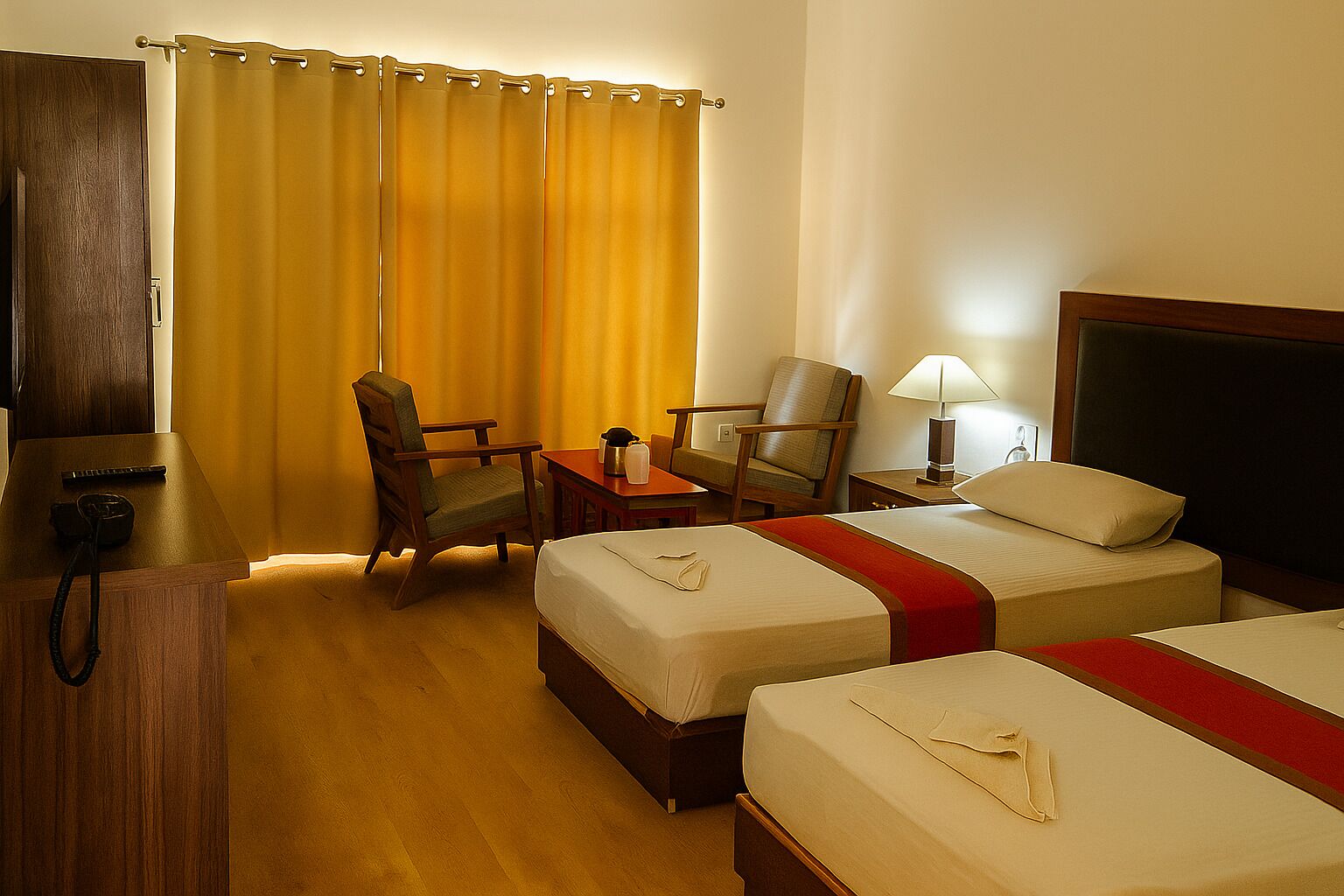 Una habitación de hotel con dos camas, un escritorio, una silla, una lámpara y un teléfono.