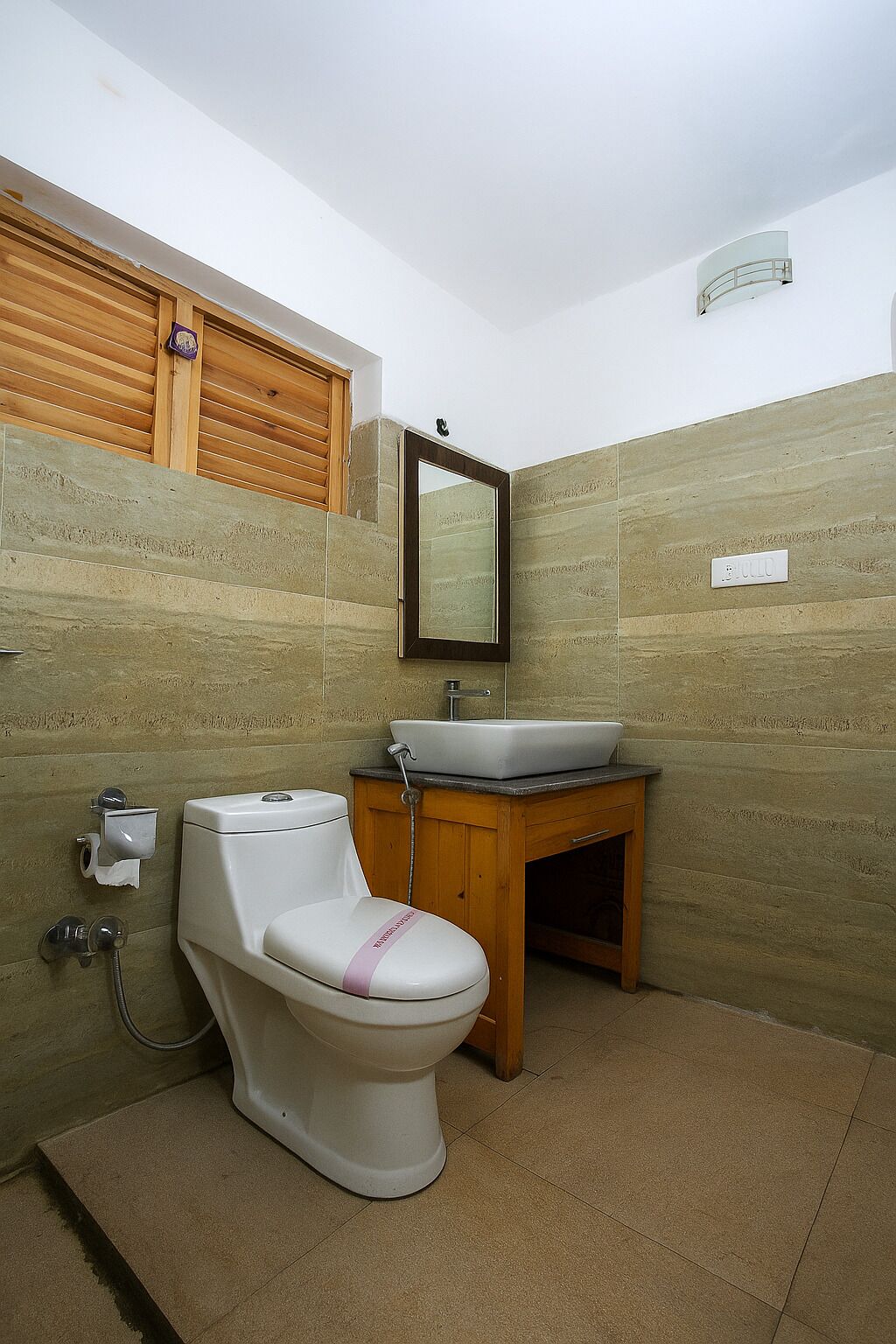 Une salle de bain avec des toilettes, un lavabo et un miroir.