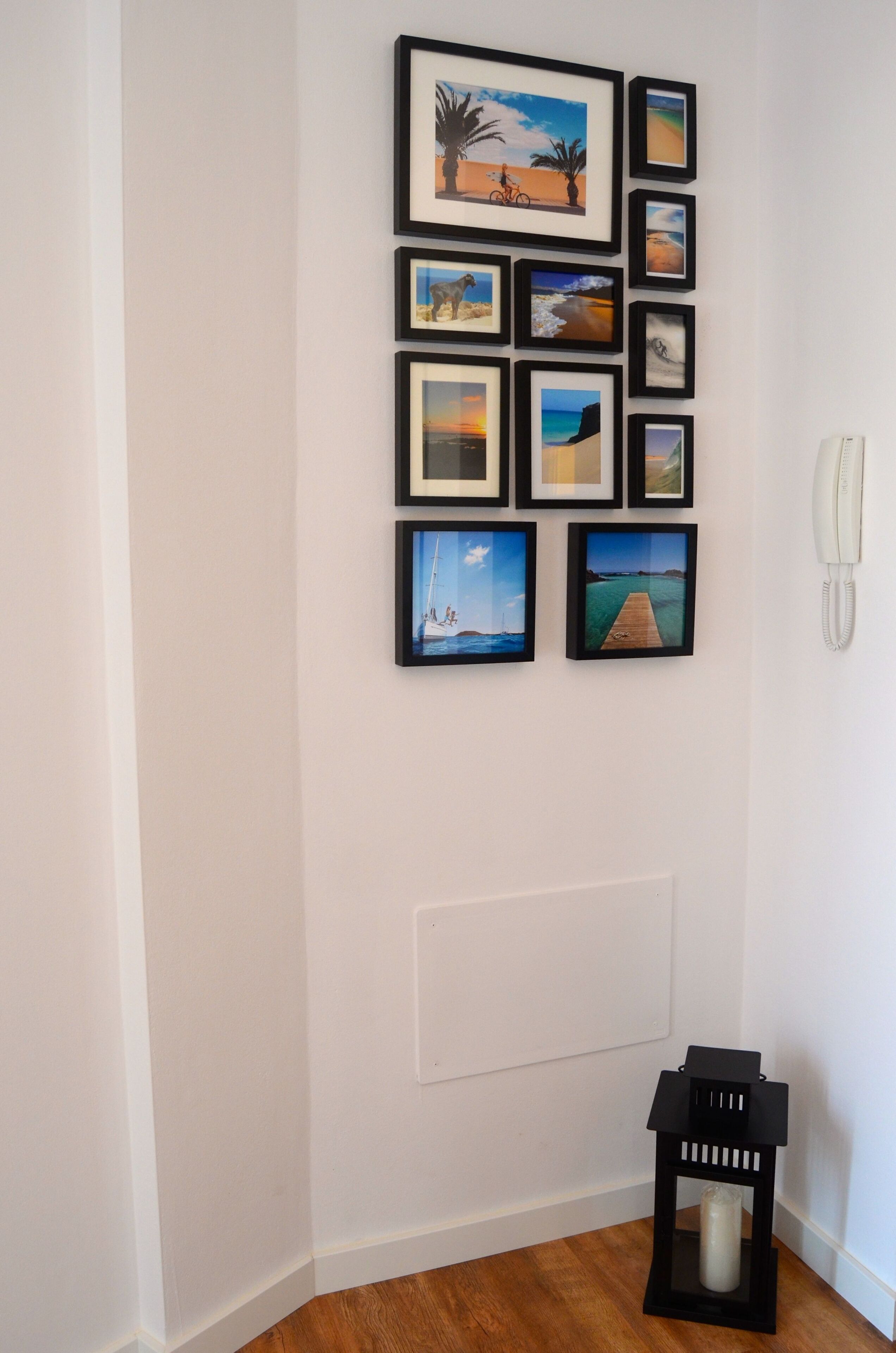 A wall with multiple framed pictures depicting various landscapes and scenes.