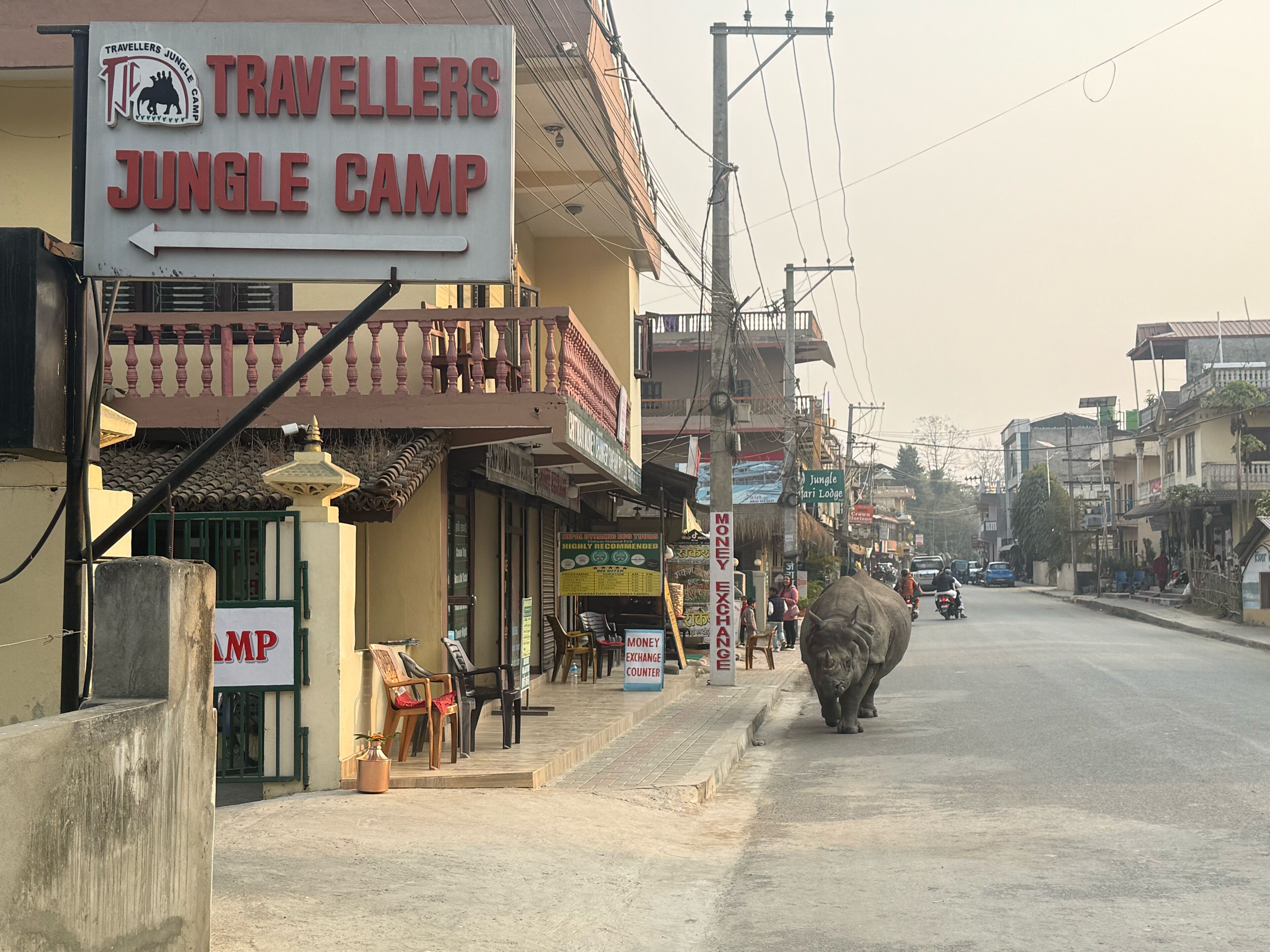 A street view with a sign for 'Travellers Jungle Camp'.