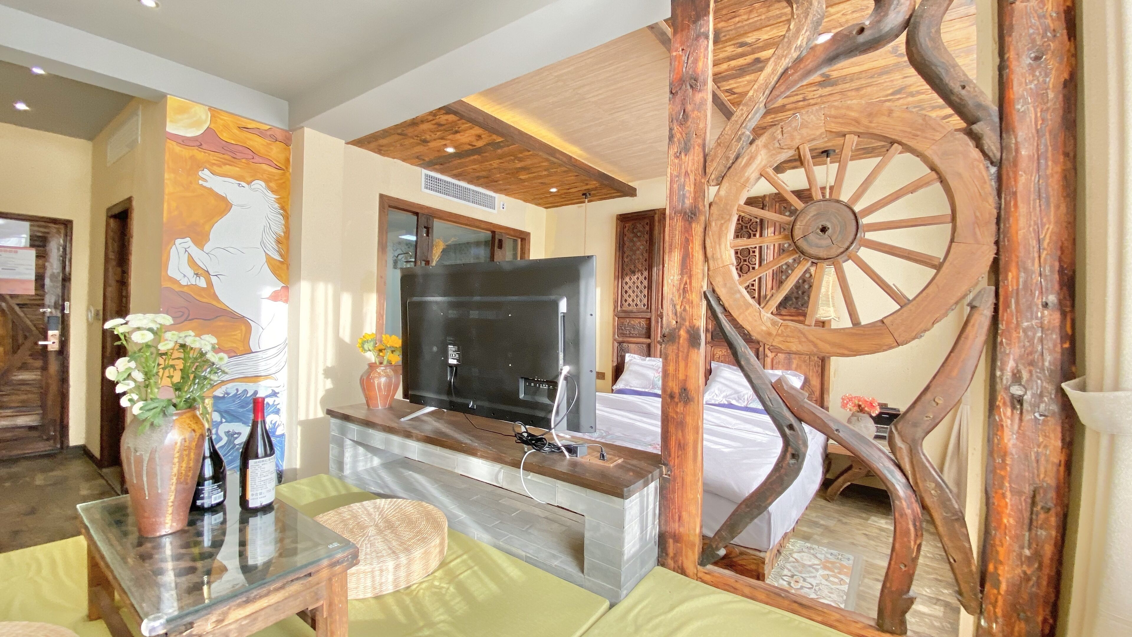 Una sala de estar con una rueda de madera, un televisor de pantalla plana y un mural de un mapa.