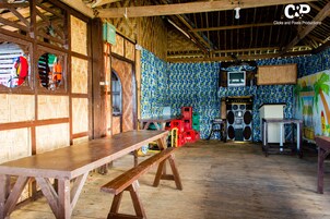 A rustic room with a wooden bench, a television, and a speaker system.