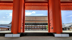A traditional Japanese building with a central entrance framed by red pillars. - Hana Botan (Kyoto)