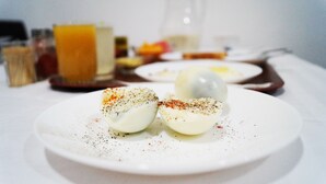 En tallrik med halverade, kokta ägg, garnerade med örter och kryddor.