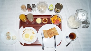 A breakfast tray with eggs, toast, fruit, and condiments. - Econo Lodge (Dar es Salaam)