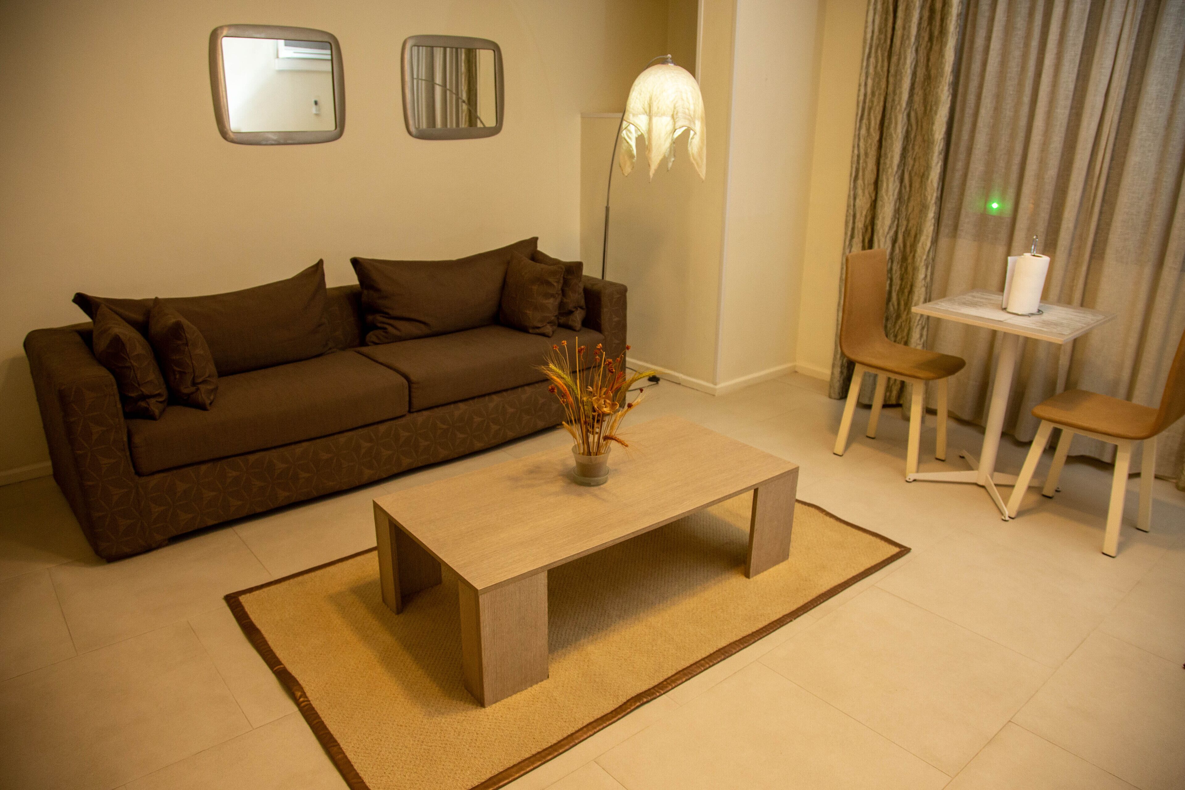 Una sala de estar con un sofá, una mesa de centro, una lámpara y una silla.