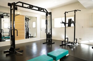 Un gimnasio con equipo de ejercicio, un espejo y una pared de madera.