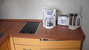 A kitchen with a coffee maker, toaster, and kettle on the counter. - Vacation apartment MAXIM - Holiday apartments (Koserow)