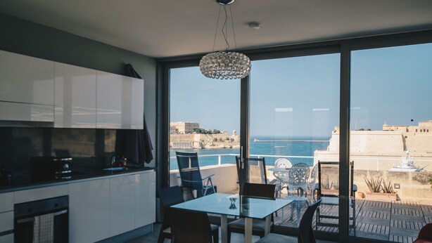 Une cuisine moderne dotée d’une grande fenêtre donnant sur une vue imprenable sur la côte.