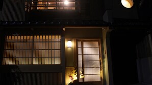 A traditional Japanese house with a wooden exterior, a sliding door, and a small balcony. - Kyomachiya Ebisu (Kyoto)