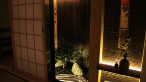 A traditional Japanese room with tatami flooring, a shoji screen, and a small rock garden. - Kyomachiya Ebisu (Kyoto)