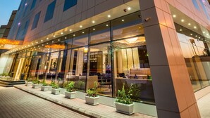 A modern hotel with a prominent glass facade, large windows, and a well-lit entrance. - Braira Al Wezarat (Riyadh)