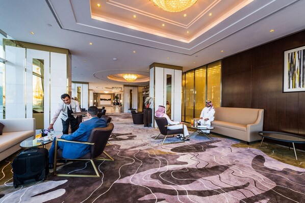 A spacious lobby with a modern design, featuring a large, patterned carpet, comfortable seating areas, and a chandelier. - Braira Al Wezarat (Riyadh)