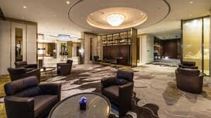 A modern lobby with leather sofas, a glass coffee table, and a chandelier. - Braira Al Wezarat (Riyadh)