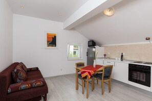 Une cuisine moderne avec un coin repas, un canapé et un tableau au mur.