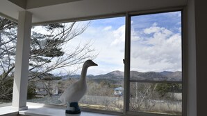 Una habitación con un amplio ventanal con vistas a un paisaje montañoso.