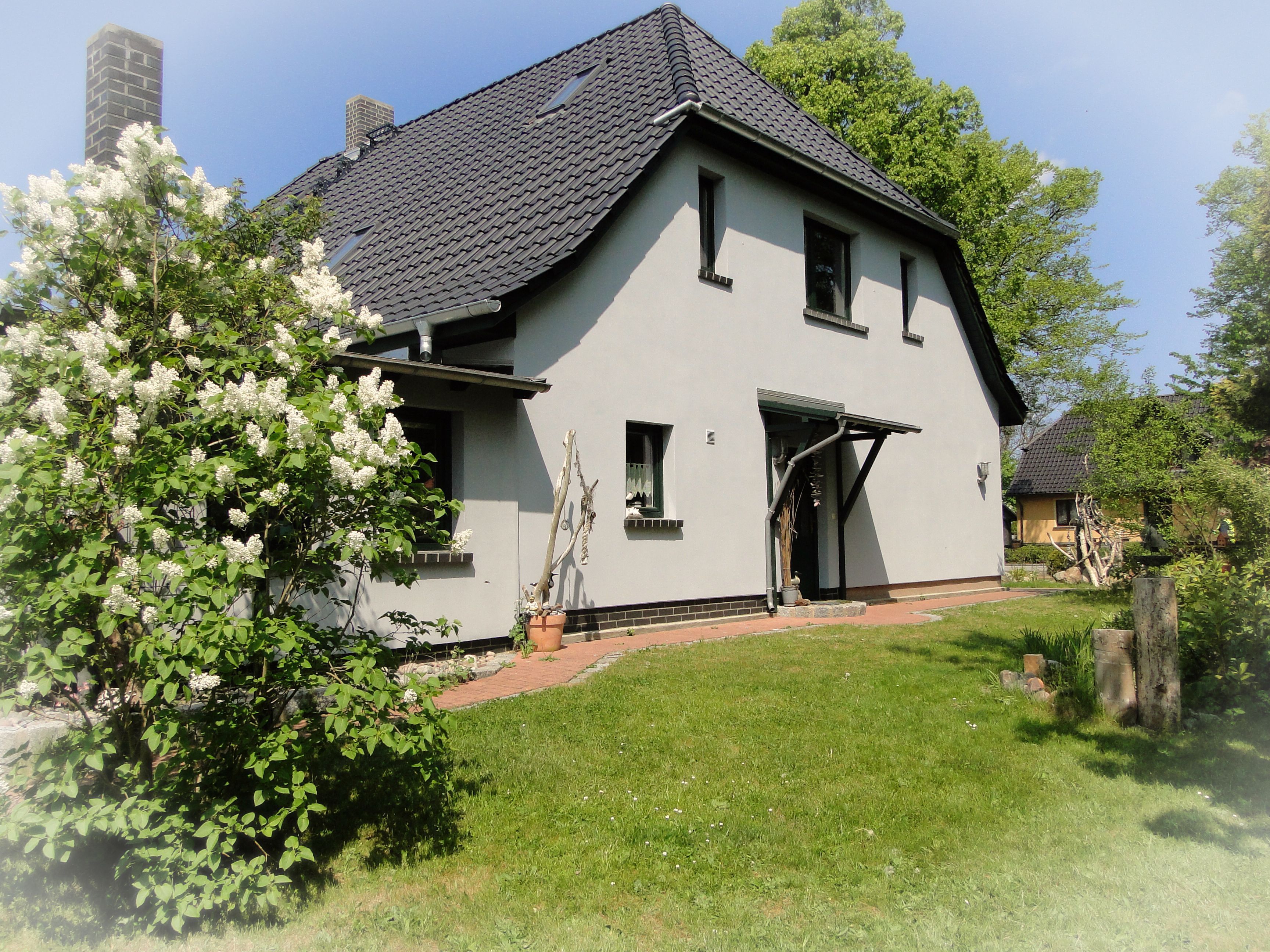 A two-story house with a sloped roof, a front door, and a small porch.