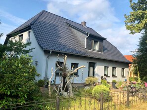A two-story house with a dark tiled roof, a visible chimney, and a small porch area. - Blue Water 1 - Blue Water 1 (Wustrow)