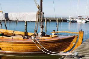 A wooden boat docked at a pier with ropes and a winch. - Thiel OG Vacation Home, Germany (Dierhagen)