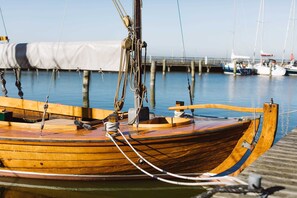 A wooden boat docked at a pier with ropes and a winch. - Thiel OG Vacation Home, Germany (Dierhagen)
