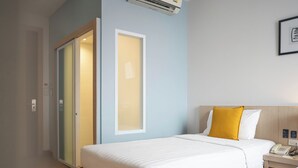 Ein Hotelzimmer mit Bett, Nachttisch und Telefon.