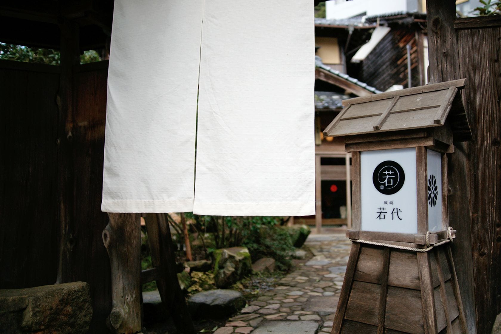 A traditional Japanese building with a wooden structure and a stone pathway.