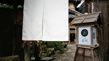 A traditional Japanese building with a wooden structure and a stone pathway.
