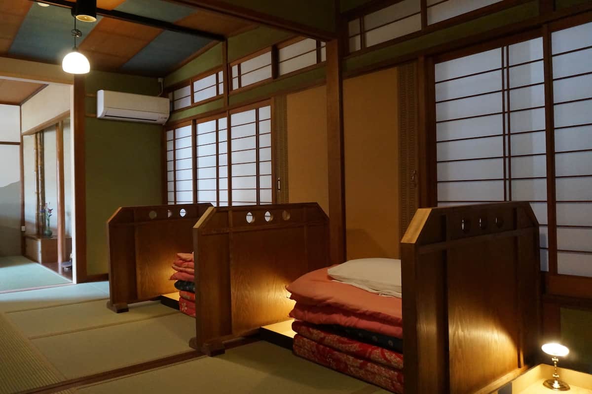 Ein traditioneller japanischer Raum mit Tatami-Boden, Shoji-Schirmen und einem Futon.
